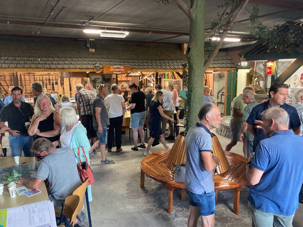 Het museum van Molen de Wachter staat vol met mensen die in gesprek zijn over de plannen